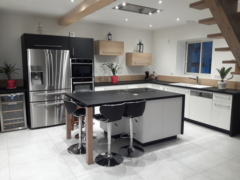 Cuisine en laque blanc mat, pieds d'îlot et crédences en chêne massif, plan de travail stratifié, meubles hauts en aggloméré chêne.